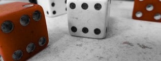 A photograph of two white and three brown large standard dice.
