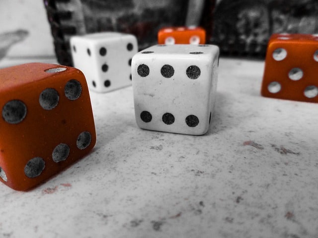 A photograph of two white and three brown large standard dice.