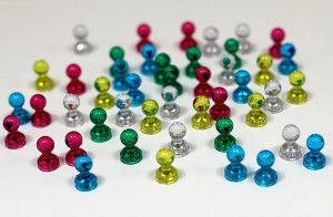 Small pawn-shaped magnets of different color, representing variance