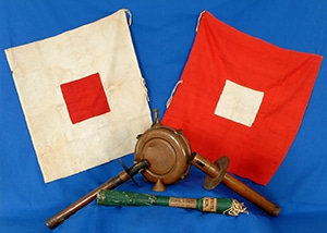 A white flag with a red square in the center, a red flag with a white square in the center, and torches