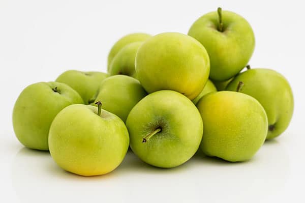 A picture of a pile of green apples