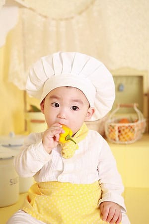 A toddler eating a pepper