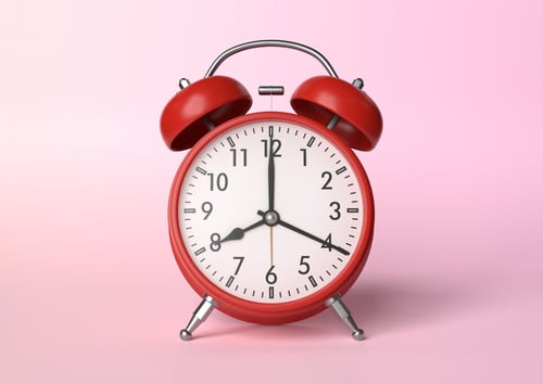 Red vintage alarm clock on bright pink background in pastel colors